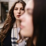 A woman standing next to another woman on a street