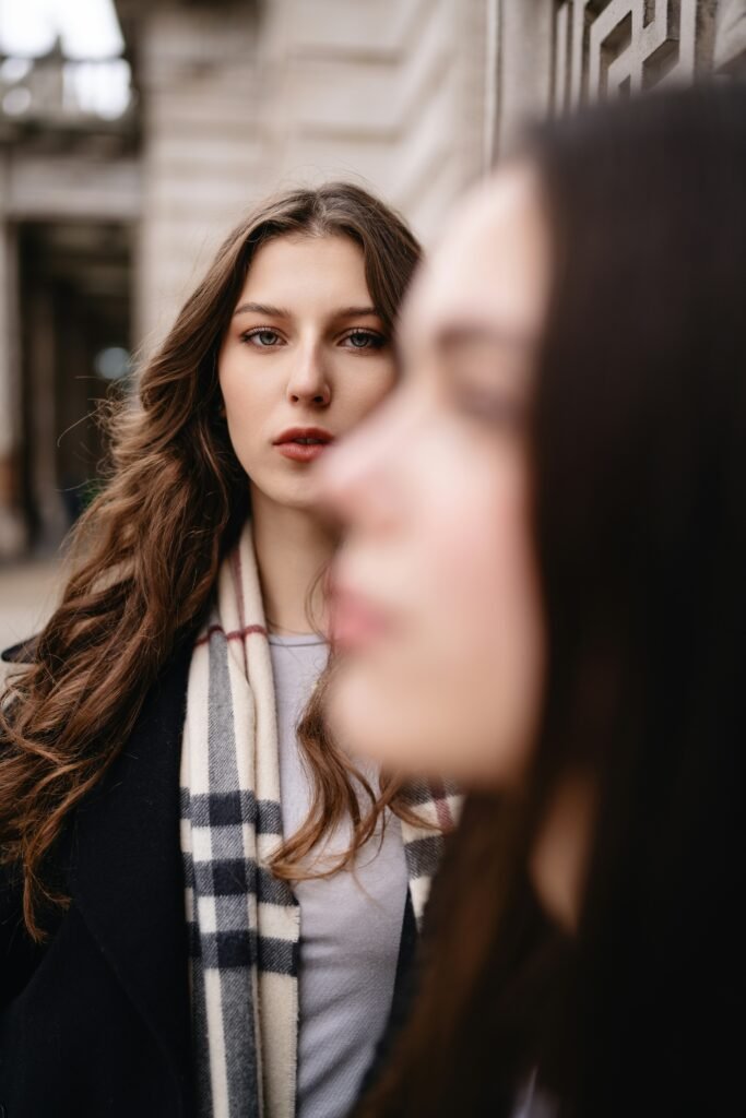 A woman standing next to another woman on a street